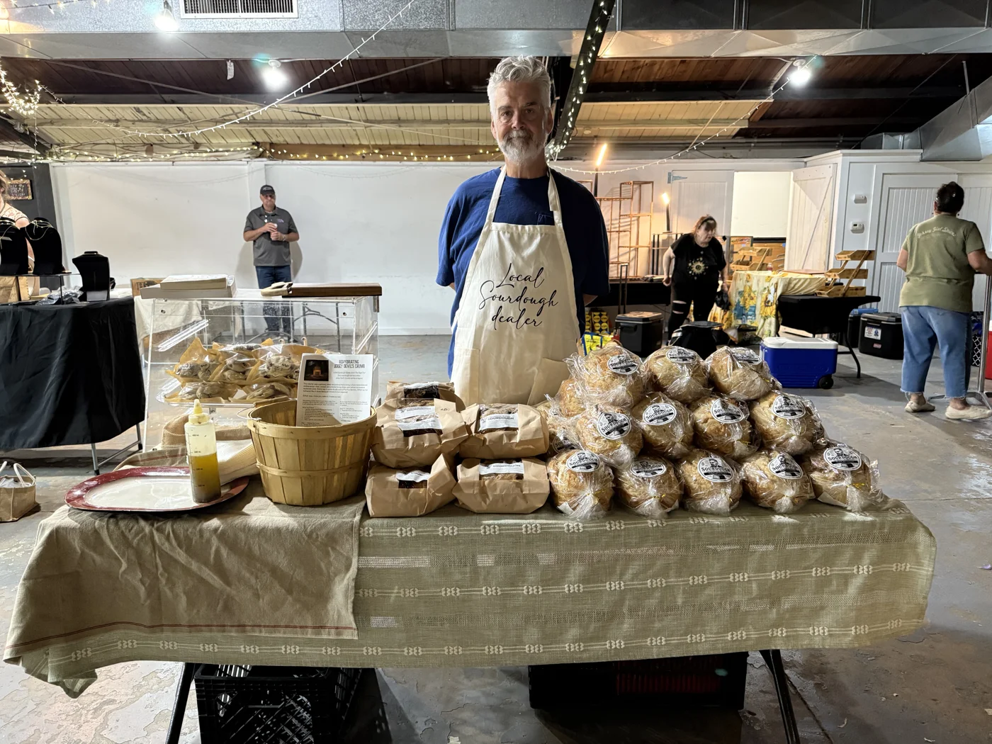 Robert behind a market table filled with his packaged sourdough